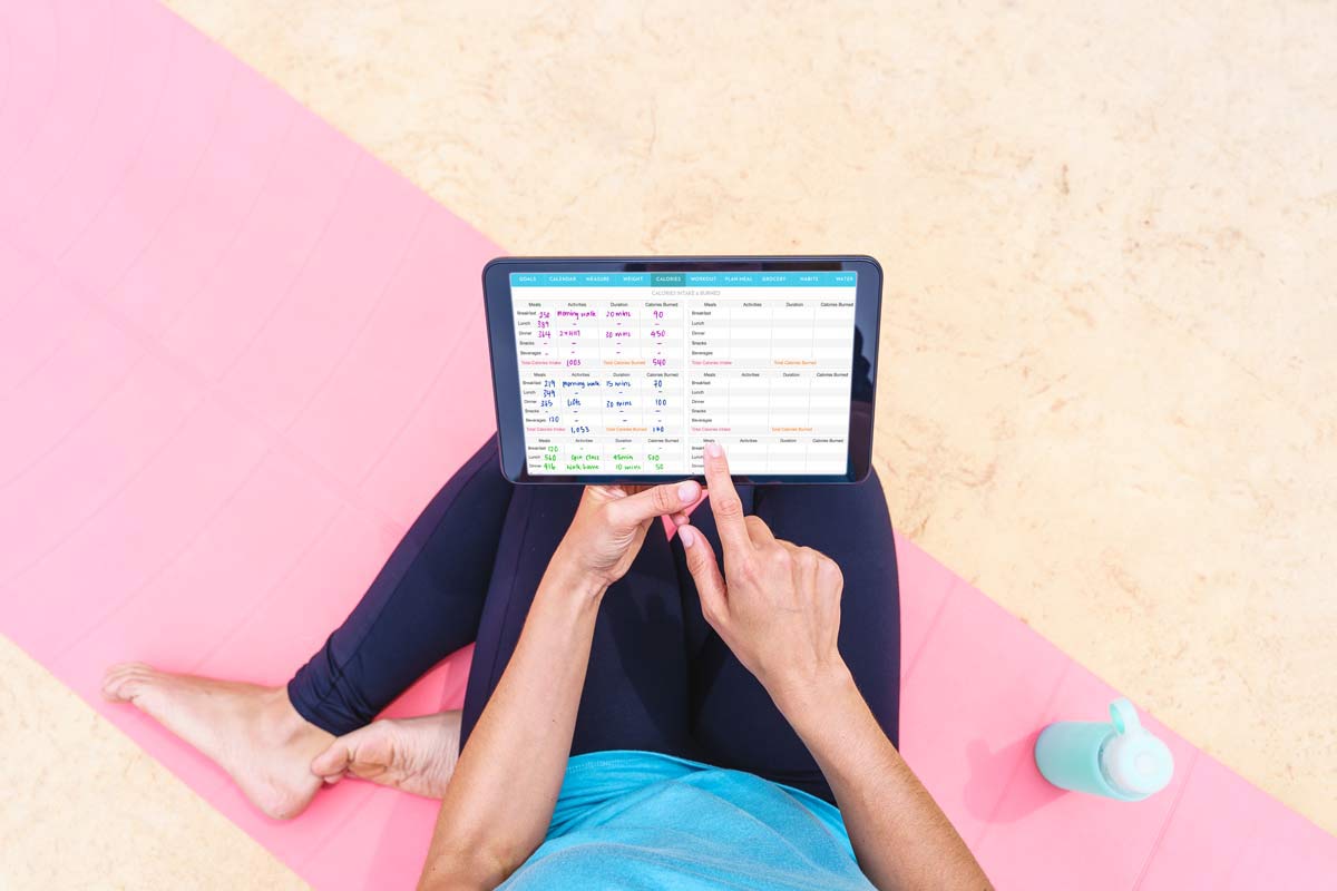 Woman in sportswear using fitness planner on ipad